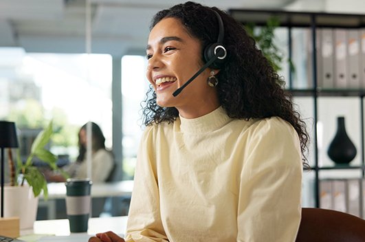 Atendente utiliza headset durante atendimento em ambiente corporativo.