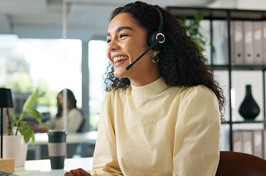 Atendente utiliza headset durante atendimento em ambiente corporativo.