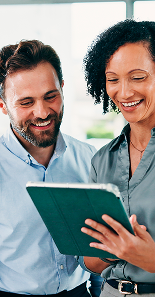 Duas pessoas consultam informações em tablet com expressão de satisfação.