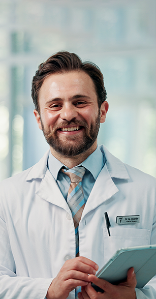 Médico sorrindo com tablet em ambiente clínico.